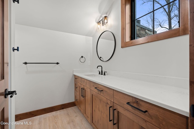 bathroom featuring vanity, baseboards, and wood finished floors