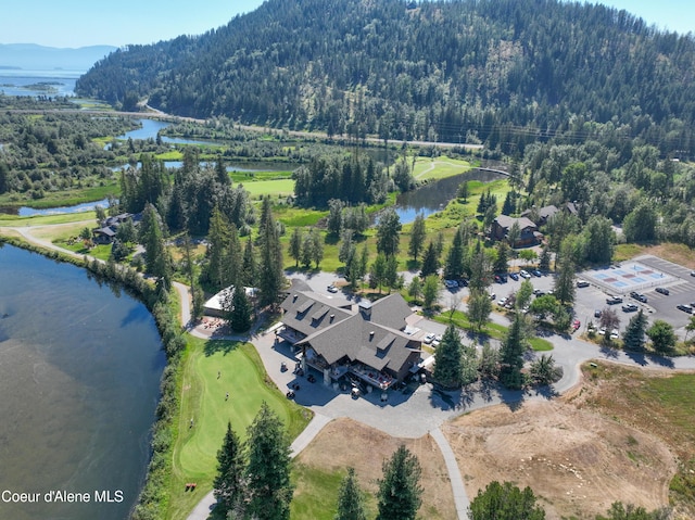 drone / aerial view with a water view and a wooded view