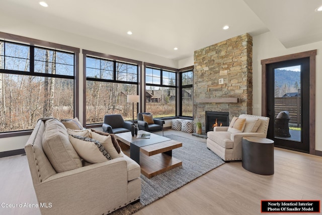 living area with baseboards, a fireplace, wood finished floors, and recessed lighting