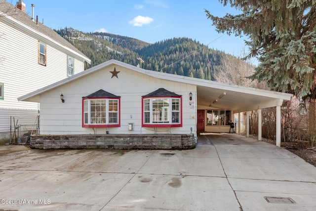 view of front facade featuring a carport, concrete driveway, and a mountain view