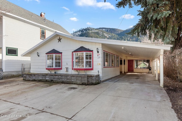 view of front of property featuring driveway, a mountain view, and a carport