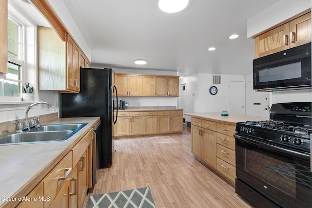 kitchen featuring black appliances, a sink, and light countertops