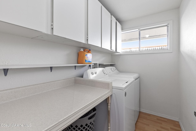 laundry area with washer and clothes dryer, light wood-type flooring, cabinet space, and baseboards