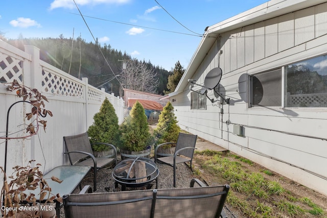 view of patio featuring an outdoor fire pit and fence