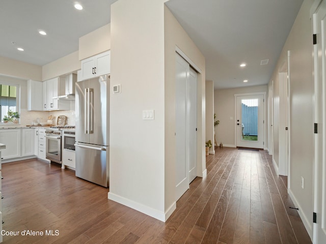 hallway featuring recessed lighting, baseboards, and dark wood-style flooring