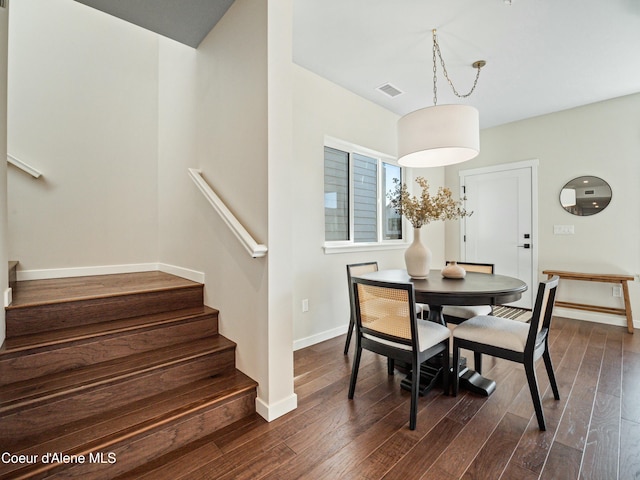 dining space featuring stairway, baseboards, visible vents, and dark wood-style flooring