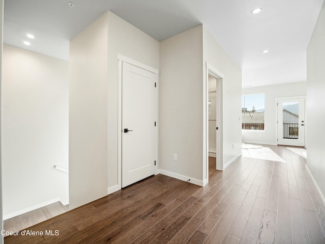 hallway featuring dark wood-style floors, recessed lighting, and baseboards