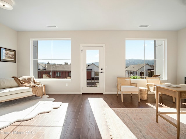 doorway to outside with visible vents, baseboards, and dark wood-style flooring