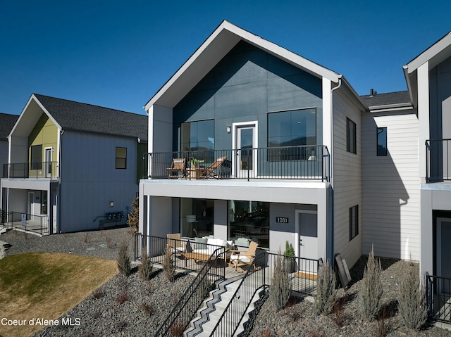 rear view of property with a balcony and a patio area