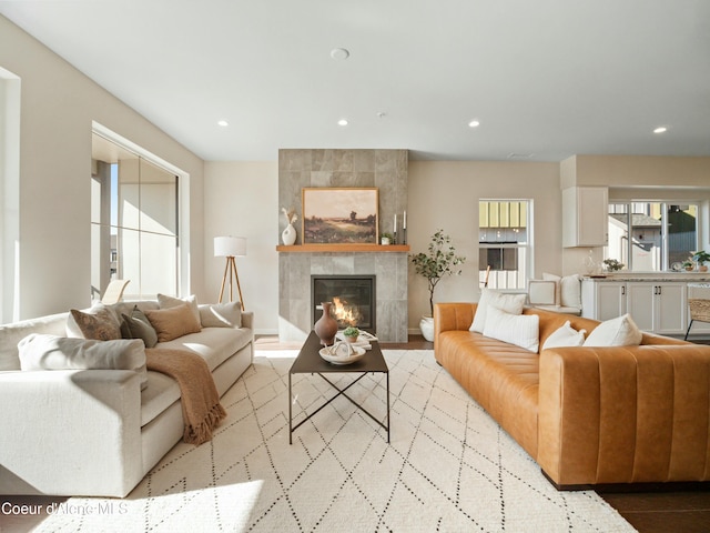 living room featuring recessed lighting, baseboards, and a tiled fireplace