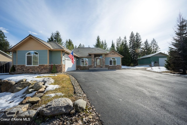 craftsman-style house with an attached garage, stone siding, and driveway