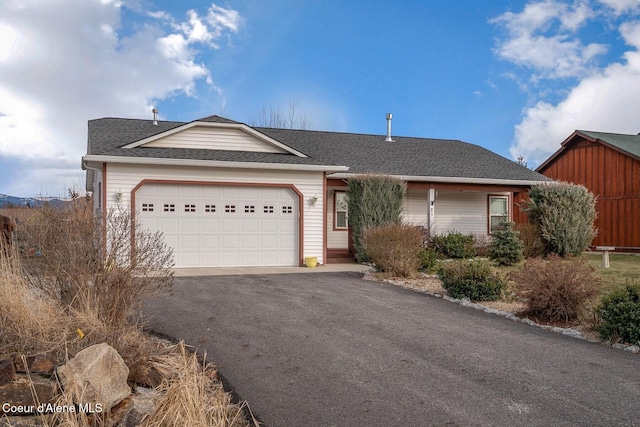 ranch-style home featuring a garage, aphalt driveway, and a shingled roof