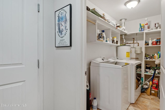 clothes washing area featuring water heater, laundry area, and washer and clothes dryer