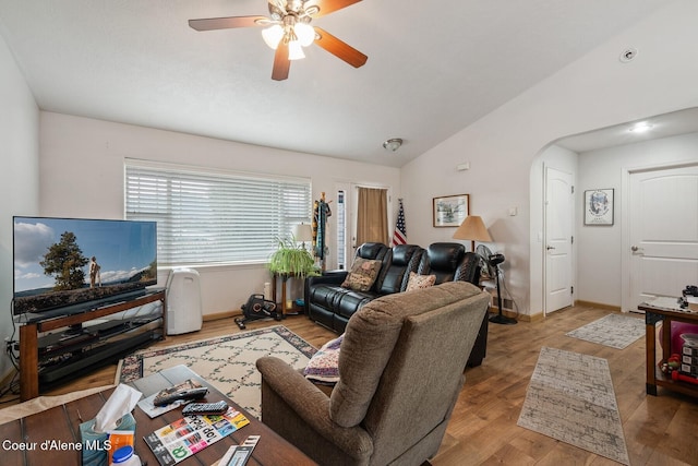 living area featuring ceiling fan, baseboards, lofted ceiling, wood finished floors, and arched walkways