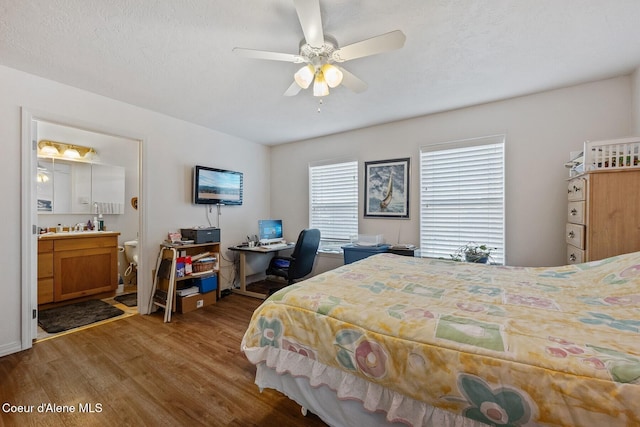 bedroom featuring ensuite bathroom, a ceiling fan, and wood finished floors