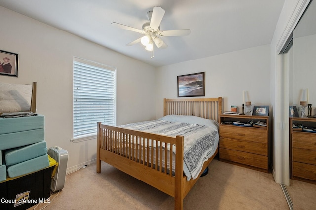 bedroom with ceiling fan, baseboards, a closet, and light carpet