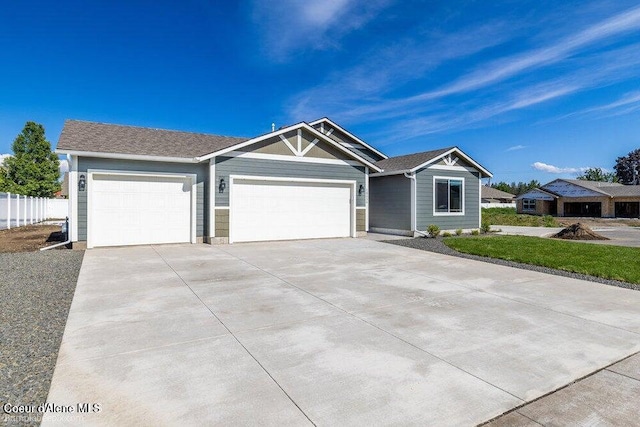 ranch-style house with a garage, driveway, and fence