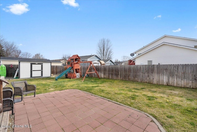 view of patio with an outbuilding, a fenced backyard, a playground, and a storage shed