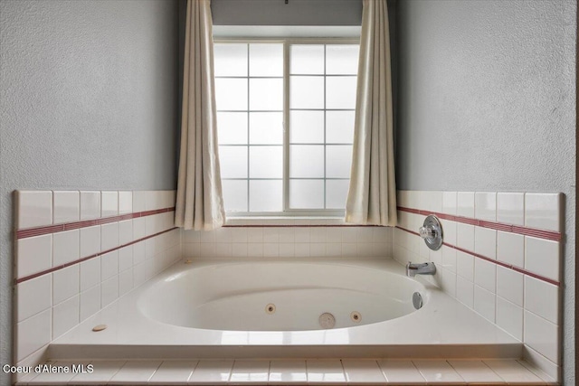 full bath featuring a textured wall and a whirlpool tub