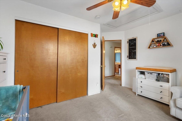 bedroom featuring a closet, attic access, carpet flooring, ceiling fan, and baseboards