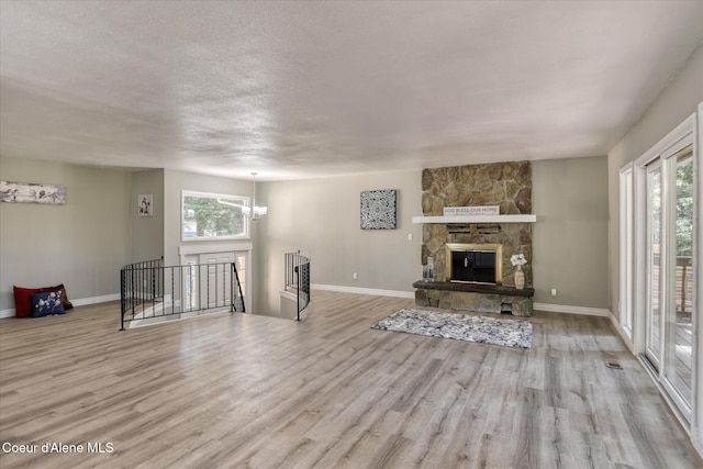 living room with a healthy amount of sunlight, a fireplace, baseboards, and wood finished floors