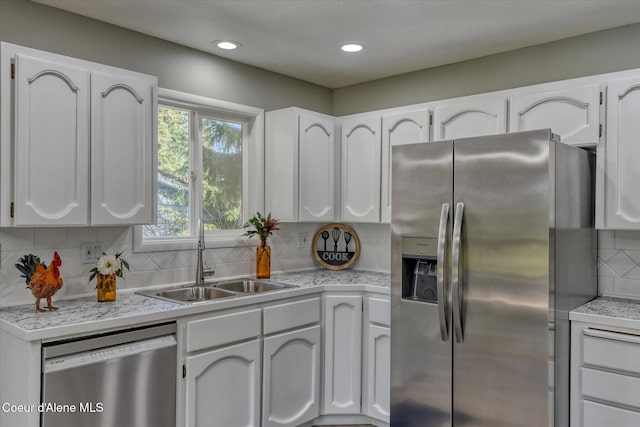 kitchen with a sink, stainless steel appliances, and white cabinetry