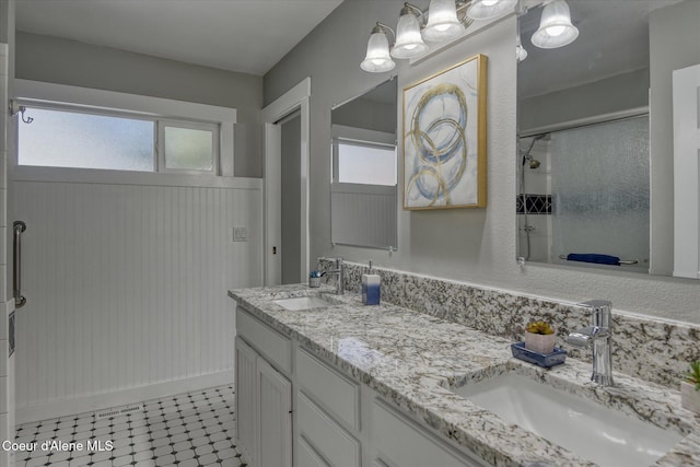 full bathroom with a shower with door, plenty of natural light, and a sink