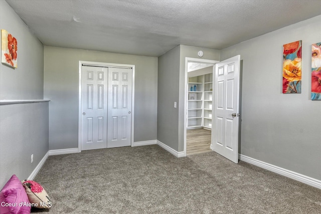 unfurnished bedroom featuring a closet, baseboards, a textured ceiling, and carpet flooring