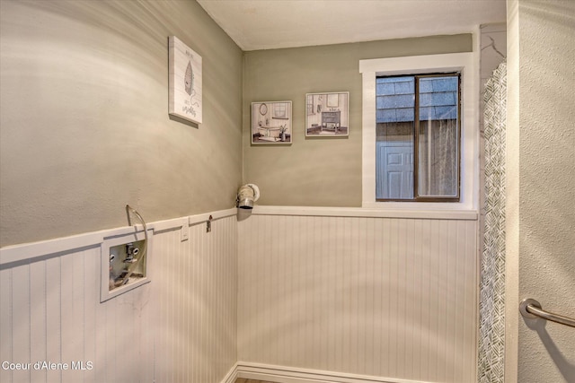 washroom featuring laundry area and a wainscoted wall