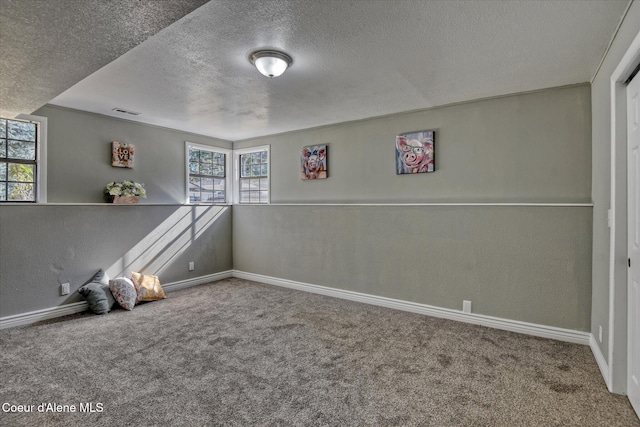 unfurnished room featuring carpet, a textured wall, and a textured ceiling