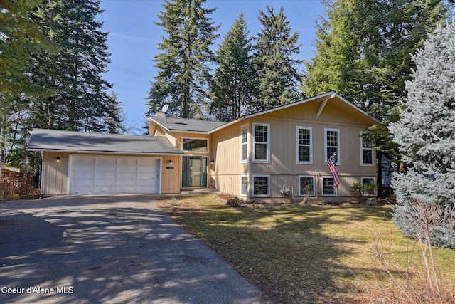 view of front facade with a front yard, an attached garage, and driveway