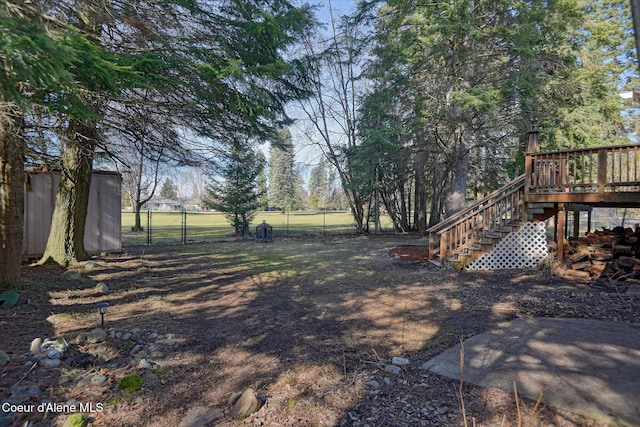 view of yard featuring a gate, stairway, a deck, and fence