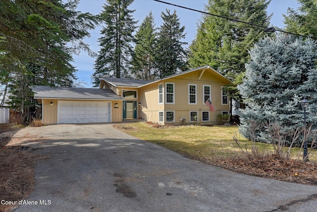 tri-level home featuring a front yard, an attached garage, and driveway