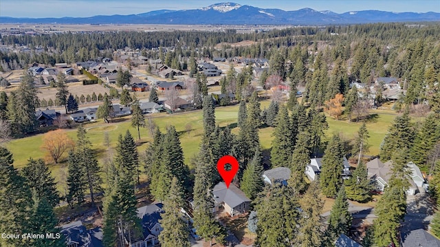 drone / aerial view featuring a residential view, a mountain view, and a view of trees