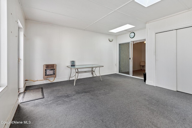 interior space featuring a skylight, carpet, and heating unit