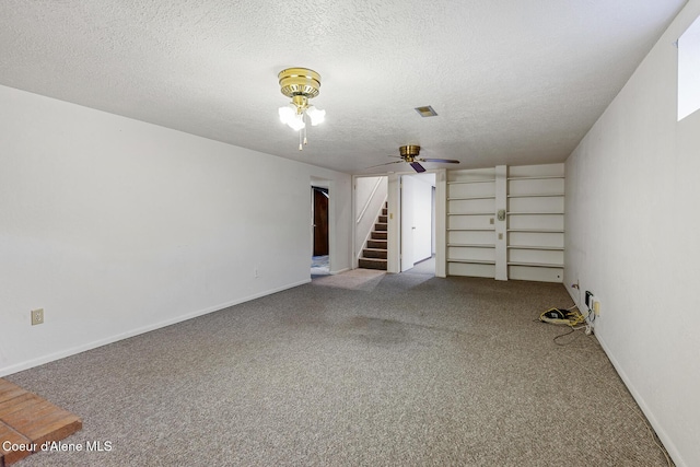 carpeted spare room featuring stairs, a textured ceiling, a ceiling fan, and baseboards