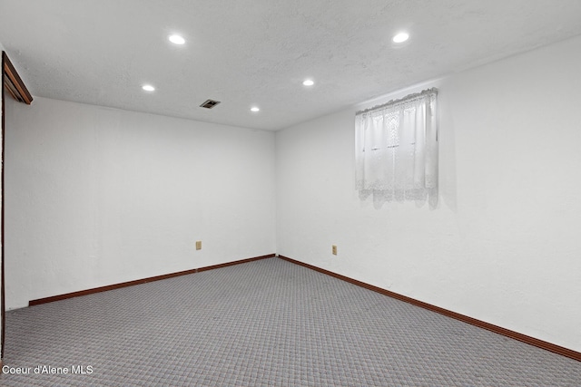 carpeted empty room featuring recessed lighting, visible vents, a textured ceiling, and baseboards