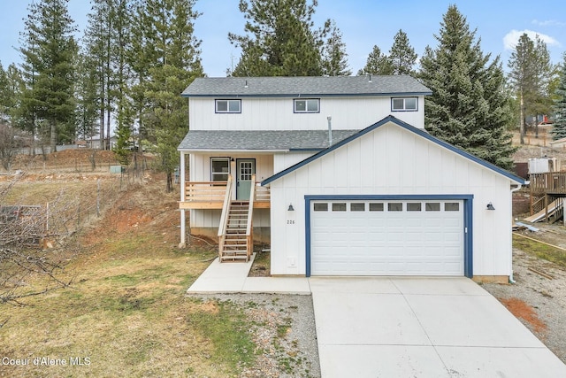 view of front facade featuring a garage, concrete driveway, stairway, and roof with shingles