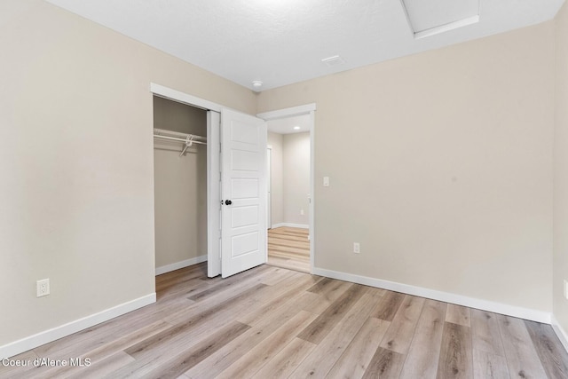 unfurnished bedroom featuring a closet, wood finished floors, and baseboards