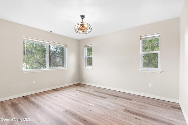 empty room featuring baseboards and light wood-style floors