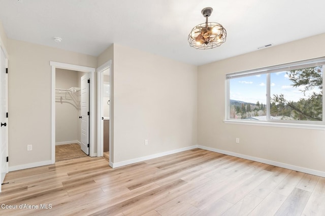 interior space with light wood-type flooring, visible vents, and baseboards