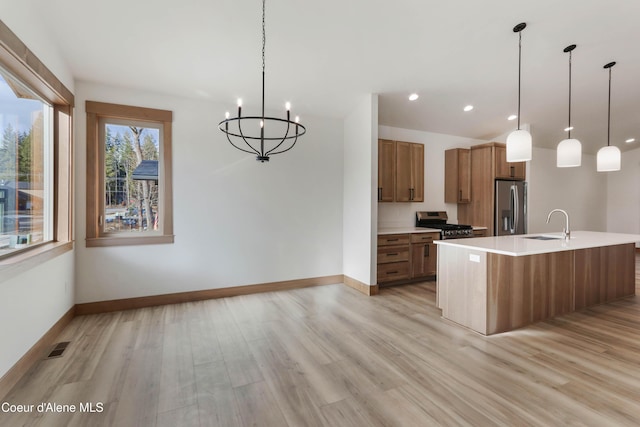 kitchen featuring brown cabinetry, baseboards, stainless steel appliances, and light wood finished floors