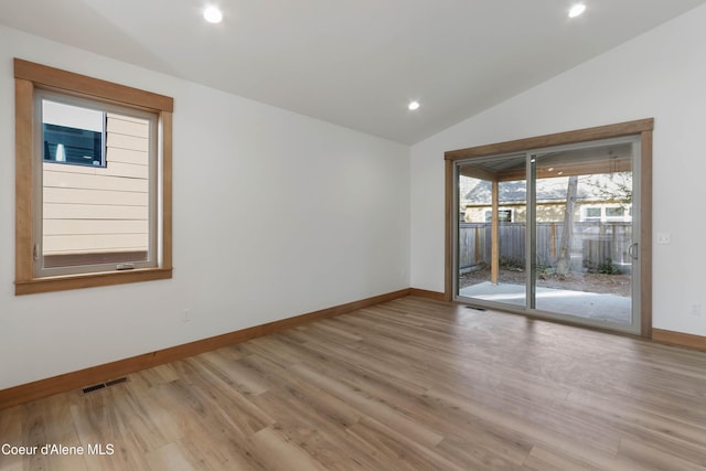 spare room with lofted ceiling, recessed lighting, wood finished floors, visible vents, and baseboards