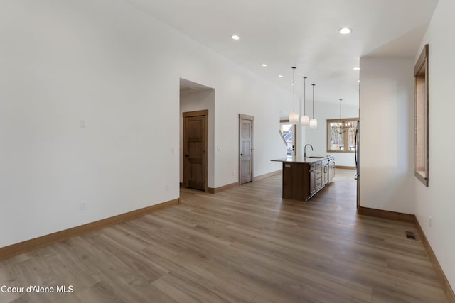 kitchen featuring visible vents, an island with sink, wood finished floors, an inviting chandelier, and recessed lighting