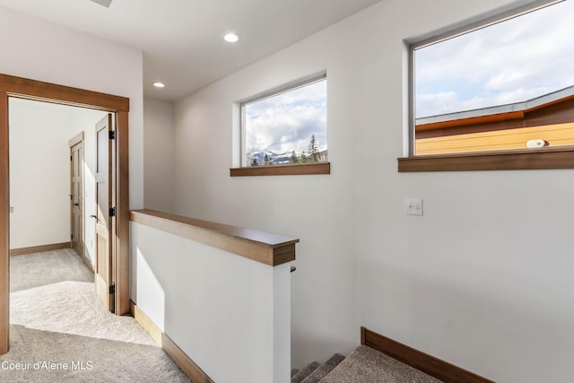 corridor featuring baseboards, carpet, an upstairs landing, and recessed lighting