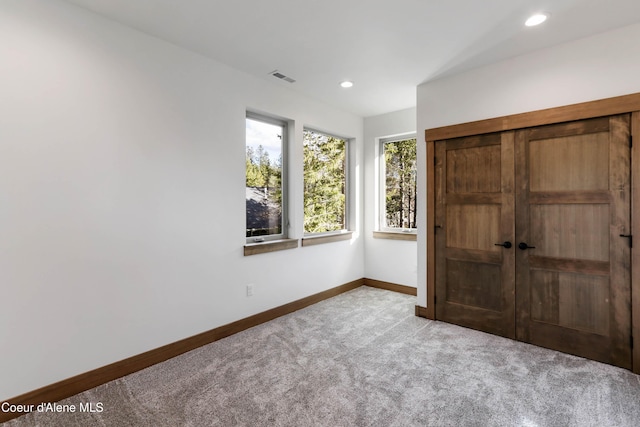 unfurnished bedroom with recessed lighting, carpet, visible vents, and baseboards