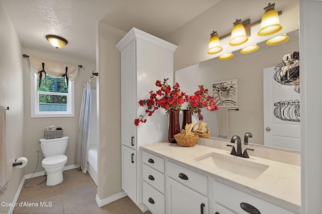 bathroom with a textured ceiling, tile patterned flooring, toilet, vanity, and baseboards