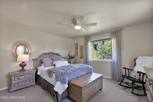 bedroom with light colored carpet, ceiling fan, a textured ceiling, and baseboards