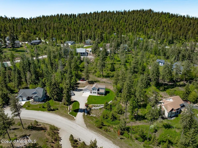 drone / aerial view featuring a wooded view