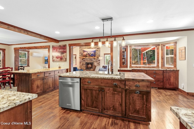 kitchen with a wealth of natural light, a fireplace, a sink, and wood finished floors